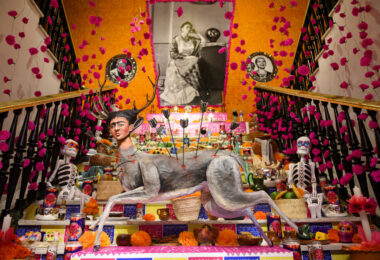 Si piensas que para vivir una auténtica experiencia del Día de Muertos tienes que volar hasta México, ¡te equivocas! La Fundación Casa de México en Madrid vuelve a celebrar este año su séptima edición del Altar de Muertos, y no es cualquier altar. Detrás de su diseño está nada más y nada menos que Eugenio Caballero, el director artístico mexicano galardonado con un Oscar. Así que si te encuentras en Madrid, esta es tu oportunidad para sumergirte en una de las tradiciones más emblemáticas de México sin moverte de la ciudad. Un viaje entre la vida y la muerte El Altar de Muertos no es simplemente un espacio decorado. Este año, la intervención abarca desde la fachada de la Casa de México hasta su segunda planta, recorriendo escaleras, pasillos y todos los rincones de la casa. El diseño está inspirado en el recorrido simbólico que realizan los difuntos, un trayecto del limbo al mundo de los vivos. Esta idea se refleja en cada detalle del altar, creando una atmósfera única que nos recuerda que la muerte no es el final, sino parte de un ciclo que nos conecta con nuestros seres queridos. El concepto central del altar es la dualidad: la vida y la muerte, el día y la noche, el sol y la luna, el cielo y el inframundo. Cada espacio está cuidadosamente diseñado para hacerte sentir esta dualidad, desde los colores vibrantes hasta la manera en que las luces juegan con las sombras. Además, por primera vez, la instalación te invita a vivir la experiencia con todos tus sentidos. Es mucho más que un simple altar, es una celebración inmersiva. El arte detrás del altar La pieza central del altar es un dibujo del maestro Javier Martínez Pedro, quien ha plasmado en su obra un camino que simboliza el viaje de la muerte hacia la vida. Esta ofrenda no solo es una representación visual de la festividad, sino que es un homenaje a una tradición milenaria que sigue viva y que ahora se extiende hasta Madrid. La elección de Martínez Pedro y de Eugenio Caballero no es casual. Ambos artistas han sabido capturar el alma del Día de los Muertos, combinando elementos prehispánicos con influencias contemporáneas, lo que da como resultado una experiencia artística que va más allá de lo visual. Es una invitación a reflexionar sobre la muerte, pero también sobre la vida, una celebración que nos recuerda que ambos conceptos están profundamente conectados. ¿Cómo y cuándo visitar el Altar de Muertos? Tienes tiempo hasta el 10 de noviembre para visitar este espectacular altar, así que no hay excusas. Puedes hacerlo de lunes a domingo, y sí, también los festivos como el 12 de octubre, el 1 y el 9 de noviembre. La Casa de México ha organizado recorridos guiados de 25 minutos, en los que podrás conocer todos los detalles del altar y su significado. Si prefieres esta opción, ten en cuenta que es necesario estar suscrito a la newsletter de la fundación para comprar las entradas. Los recorridos guiados son una excelente opción si quieres comprender a fondo la historia y el simbolismo detrás de cada elemento del altar. Pero si lo tuyo es más pasear a tu ritmo, no te preocupes, también hay horarios de acceso libre. El lunes puedes visitar la casa de 10 a 18:45 horas, mientras que de martes a viernes el acceso es de 10 a 15:30 horas. Y si prefieres aprovechar el fin de semana, el sábado y el domingo está abierto de 10 a 12:30 horas. Así que planifica bien tu visita y no te pierdas esta experiencia única. ¿Por qué no te puedes perder esta edición? El Día de Muertos es una festividad que ha sido reconocida como Patrimonio Cultural Inmaterial de la Humanidad por la UNESCO, y con razón. Es una celebración que mezcla la solemnidad con la alegría, la memoria con el presente. Este altar no solo es un homenaje a quienes ya no están, sino también un espacio para compartir recuerdos, emociones y, sobre todo, para conectar con una tradición que sigue muy viva. Madrid ha tenido la suerte de acoger este evento durante siete años consecutivos, y con cada edición, la Casa de México ha sabido superarse. Este año, la apuesta ha sido aún mayor, no solo por el calibre de los artistas implicados, sino por la manera en que han logrado que cada visitante se sienta parte de la tradición. La posibilidad de experimentar la dualidad entre la vida y la muerte de una forma tan inmersiva es un lujo que no se encuentra todos los días. Así que, si te interesa el arte, la cultura o simplemente quieres conocer una de las tradiciones más hermosas de México, este altar es una parada obligada. Un evento para todos los sentidos Si algo destaca de esta séptima edición es la capacidad de envolverte por completo en la experiencia. No es solo lo que ves, sino lo que sientes, escuchas y hasta hueles. Cada rincón está pensado para que vivas la festividad de una forma más profunda y personal. La Casa de México se ha convertido en un puente entre culturas, y este Altar de Muertos es un claro ejemplo de cómo las tradiciones pueden viajar, transformarse y, al mismo tiempo, mantenerse fieles a sus raíces.