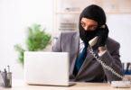 Male gangster stealing information from the office