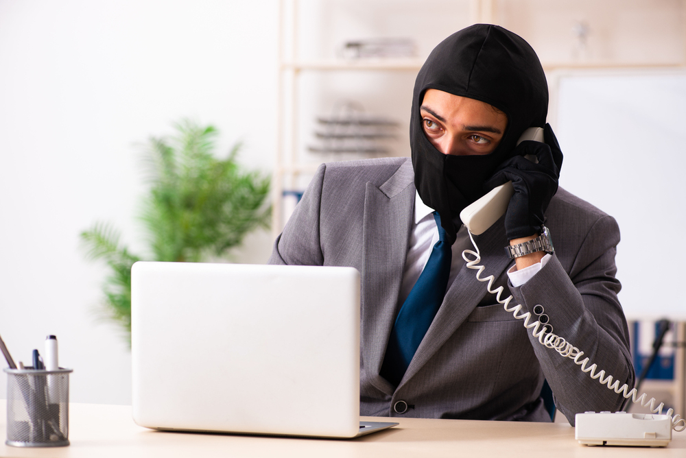 Male gangster stealing information from the office